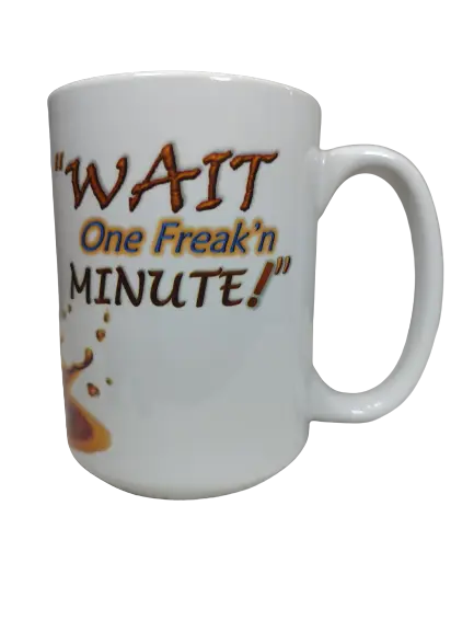 A white wait a minute mug resting on a textured white surface. The mug displays the bold, brown and orange text: "'WAIT One Freak'n MINUTE!'". Below the text, there's a graphic of brown liquid splattering, suggesting a coffee spill. This funny sarcastic mug is an excellent attitude coffee mug and novelty mug gift.
www.justsaynpromos.com